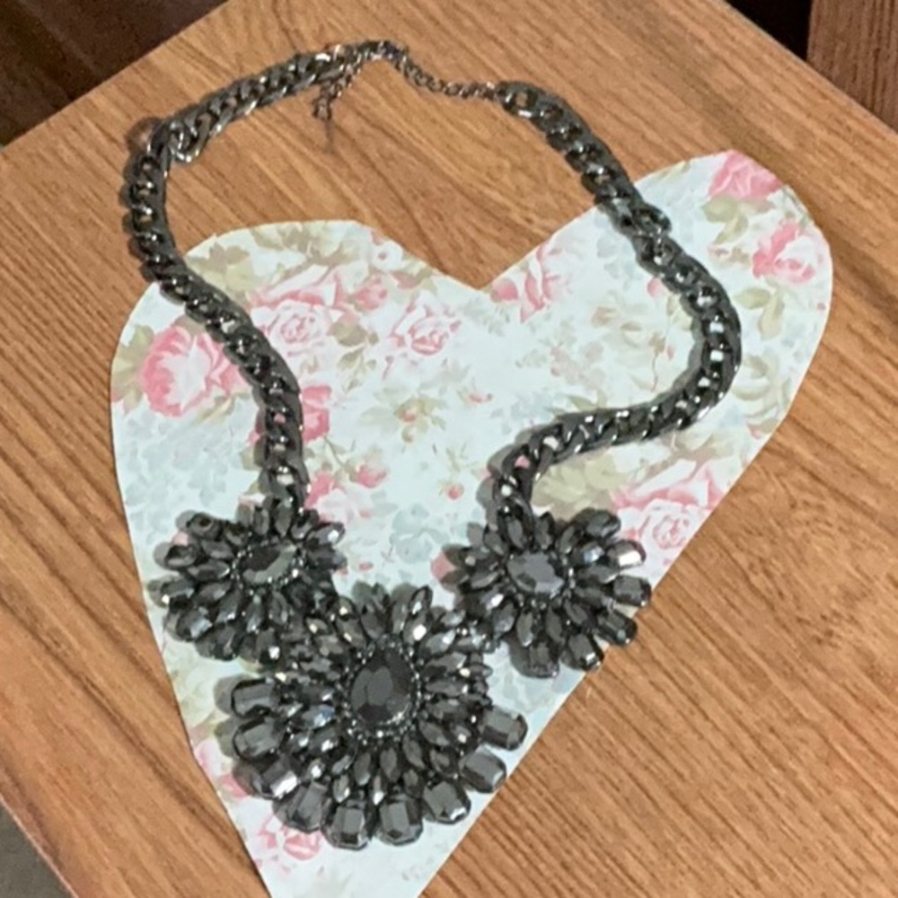 Gun metal toned statement necklace with three flower shaped pendants.